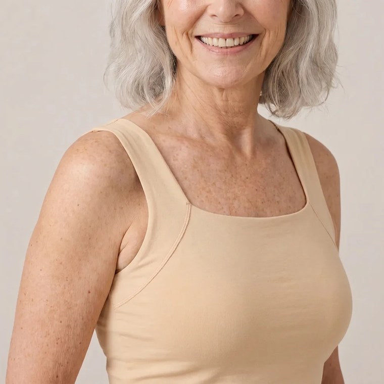 An older woman wearing Maggie's built-in-bra tank in nude, smooth and lifted.